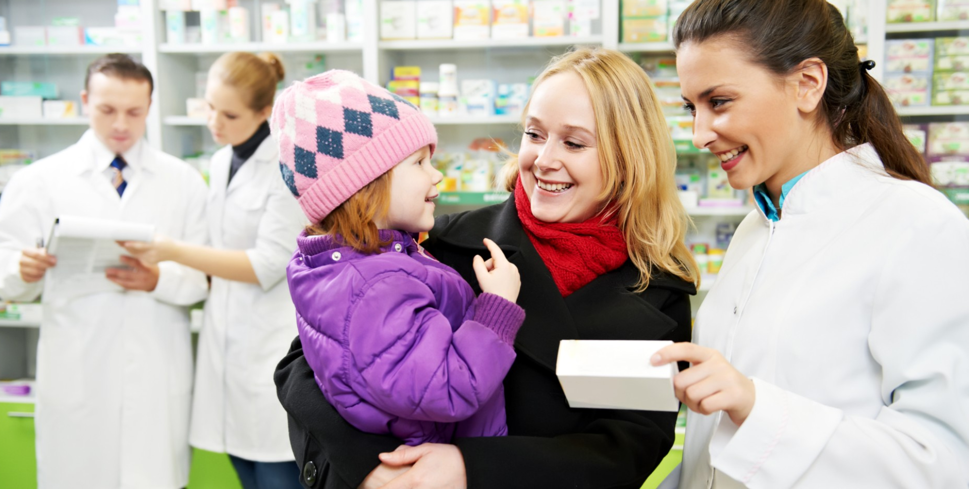 Mother with her child assisted by the pharmacist
